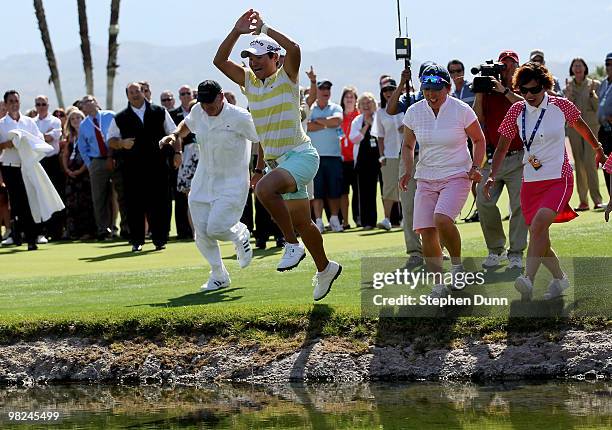 Champion Yani Tseng of Taiwan jumps in the lake surrounding the 18th green after the final round of the Kraft Nabisco Championship at Mission Hills...