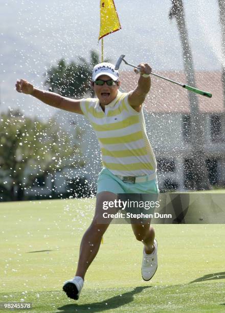 Champion Yani Tseng of Taiwan runs as Morgan Pressel sprays her with champagne on the 18th green after the final round of the Kraft Nabisco...