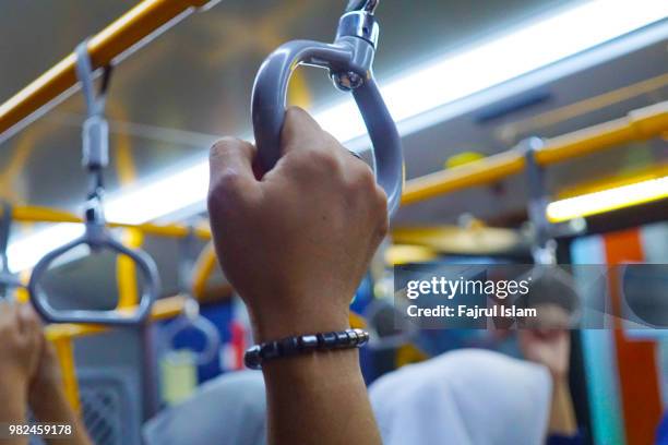man hand holding handle at train in jakarta - handle stock pictures, royalty-free photos & images