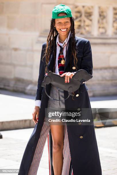Adesuwa Aighewi, wearing Thom Browne long coat and grey shorts, is seen in the streets of Paris before the Thom Browne show, during Paris Men's...
