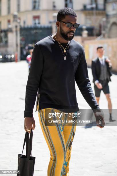 Guest, wearing black sweater and yellow pants, is seen in the streets of Paris before the Thom Browne show, during Paris Men's Fashion Week...