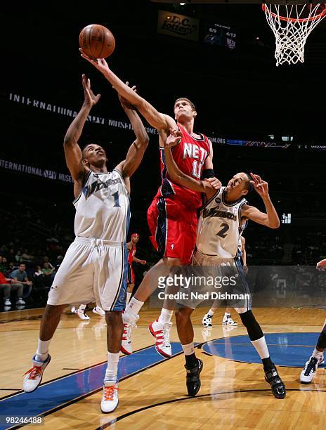 Brook Lopez of the New Jersey Nets shoots against Nick Young and Shaun Livingston of the Washington Wizards at the Verizon Center on April 4, 2010 in...