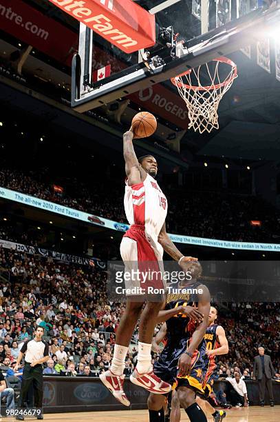 Amir Johnson of the Toronto Raptors winds up and throws down the one-handed jam ahead of Anthony Tolliver of the Golden State Warriors during a game...