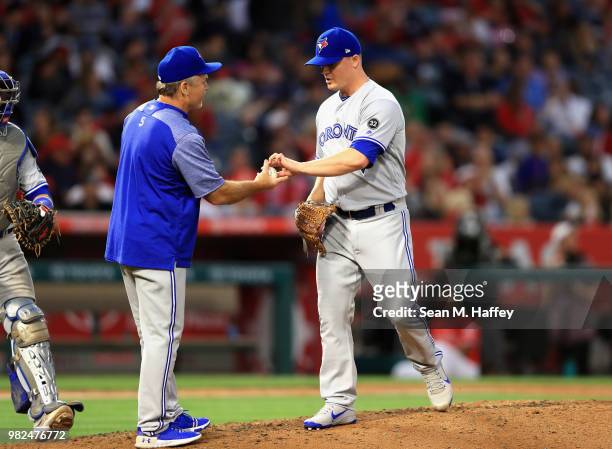 Manager John Gibbons takes out Aaron Loup of the Toronto Blue Jays during the sixth inning of a game against the Los Angeles Angels of Anaheim at...