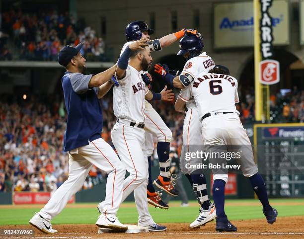 Carlos Correa of the Houston Astros is hugged by Jake Marisnick, Josh Reddick,Marwin Gonzalez and Yuli Gurriel after hitting a walkoff single in the...