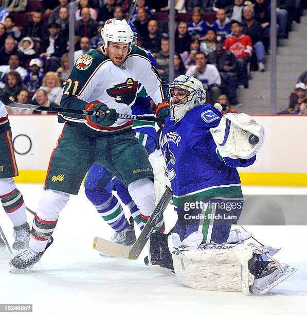 Kyle Brodziak of the Minnesota Wild watches goalie Roberto Luongo of the Vancouver Canucks make a glove during the first period of NHL action on...
