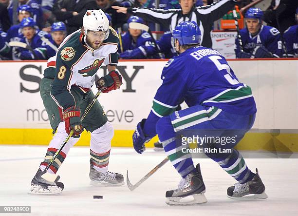 Brent Burns of the Minnesota Wild tries to get past defenceman Christian Ehrhoff of the Vancouver Canucks during the first period of NHL action on...