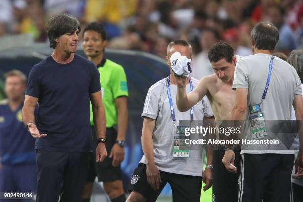 Sebastian Rudy of Germany recats next to head coach Joachim Loew following an injury during the 2018 FIFA World Cup Russia group F match between...