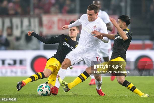 Cologne's Christian Clemens in action against Dortmund's Julian Weigl and Mahmoud Dahoud during the German Bundesliga soccer match between 1. FC...