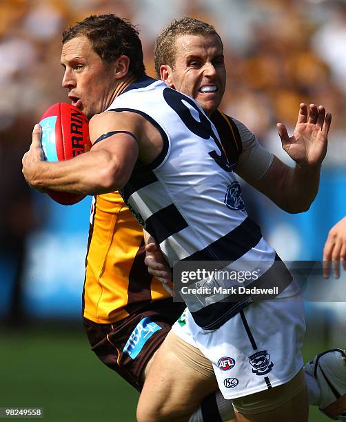 James Kelly of the Cats breaks the tackle from Michael Osborne of the Hawks during the round two AFL match between the Hawthorn Hawks and the Geelong...