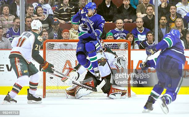 Daniel Sedin of the Vancouver Canucks jumps out of the way of teammate Sami Salo's shot as it find the back of the net past goalie Niklas Backstrom...