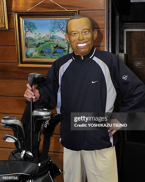 An employee of Japanese toy mask maker Ogawa Rubber wears a rubber mask resembling US top golfer Tiger Woods at the company's factory in Saitama,...