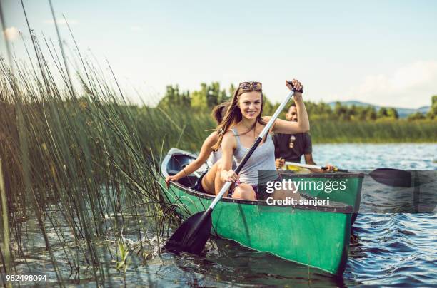 jonge vrouw kanoën op het meer - kanoën stockfoto's en -beelden