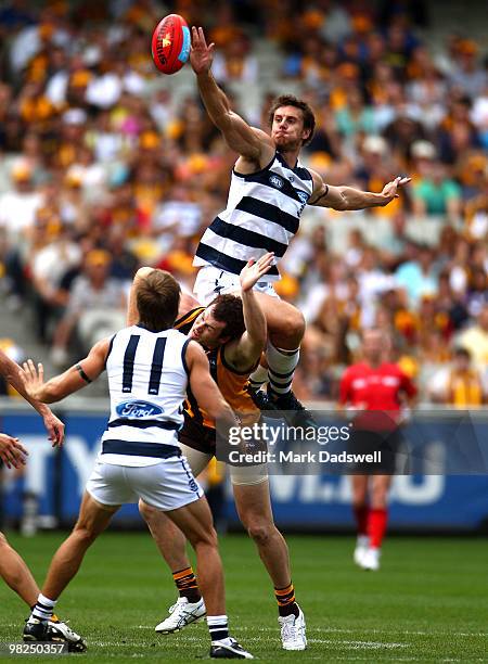 Mark Blake of the Cats jumps over Jarryd Roughead of the Hawks during the round two AFL match between the Hawthorn Hawks and the Geelong Cats at...