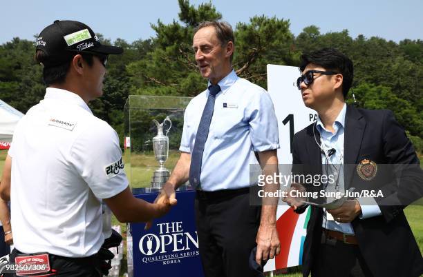 Member of The R&A Championship Committee-Professional Events Paul McKellar shakes hands with Choi Min-Chul of South Korea on the 1st hole during the...