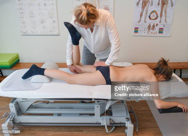 Christina Grosse Boymann, healing practitioner, osteopath and physiotherapist, treating a girl at her practice in Frankfurt an der Oder, Germany, 01...