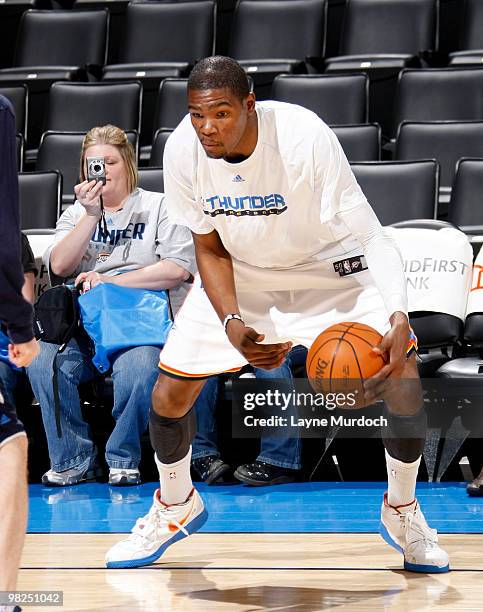 Kevin Durant of the Oklahoma City Thunder warms up in front of Jennifer Hiser, the two millionth NBA Facebook page fan before the game between...