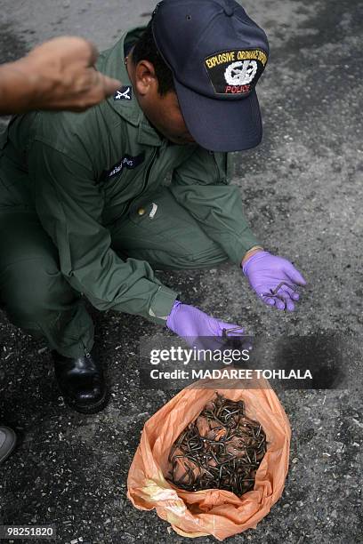 Thai police officers inspect nails found after an ambush near a Thai army base in Thailand's restive southern province of Narathiwat on April 5,...