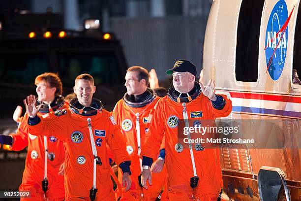 S STS-131 astronauts led by Commander Alan Poindexter and Pilot James P. Dutton Jr. Wave as they walk out of the operations and checkout building at...