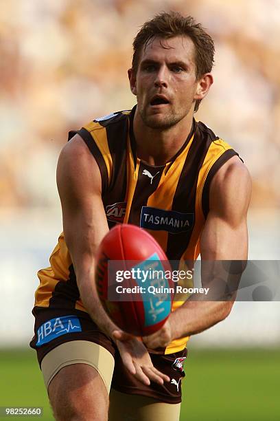 Luke Hodge of the Hawks handballs during the round two AFL match between the Hawthorn Hawks and the Geelong Cats at Melbourne Cricket Ground on April...