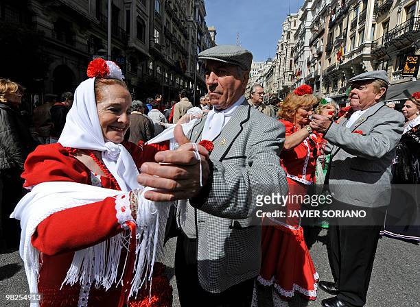 Couples perform the 'Chotis' dance as they wear typical costumes of Spain's capital Madrid known as Chulapos during a ceremony to commemorate the...