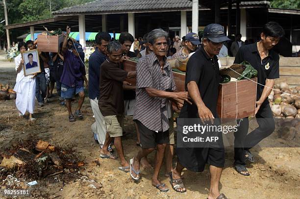 Relatives carry the coffin of one of six victims of the latest attacks by Muslim separatists during a cremation ceremony in Thailand's restive...