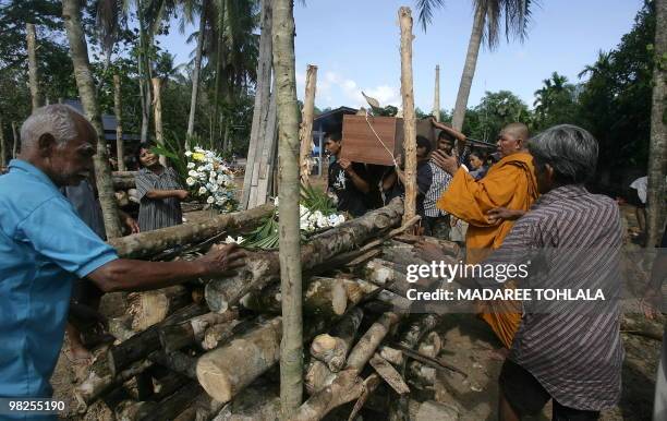 Relatives carry the coffin of one of six victims of the latest attacks by Muslim separatists during a cremation ceremony in Thailand's restive...