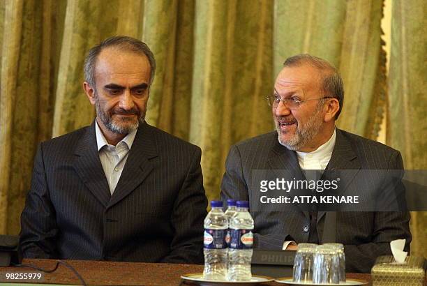 Iran's Foreign Minister Manouchehr Mottaki smiles as he and Iranian diplomat Heshmatollah Attarzadeh attend a ceremony at the Iranian Foreign...