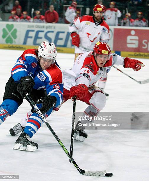 Patrick Koeppchen of Hannover and Henry Mertens of Nuremberg battle for the puck during the fourth DEL quarter final play-off game between Thomas...