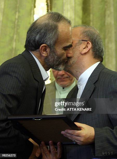 Iranian diplomat Heshmatollah Attarzadeh receives a certificate of appreciation from Iran's Foreign Minister Manouchehr Mottaki during a ceremony...