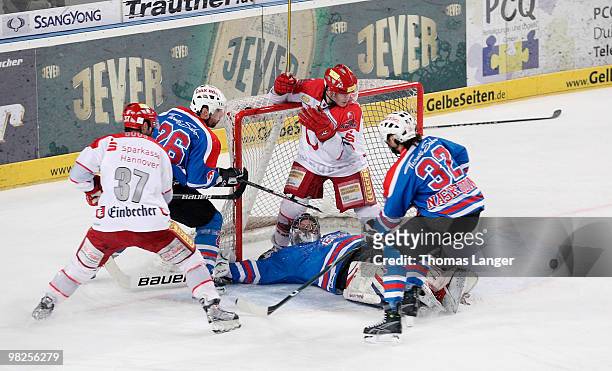 Adam Mitchell and Aris Brimanis of Hannover, Andre Savage, Patrick Ehelechner and Alain Nasreddine of Nuremberg battle for the puck during the fourth...