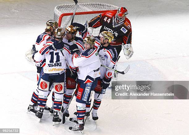 Stefan Ustorf of Berlin celebrates after scoring his team's third goal with his team mates whilst goalie Leo Dennis Endras of Augsburg looks dejected...