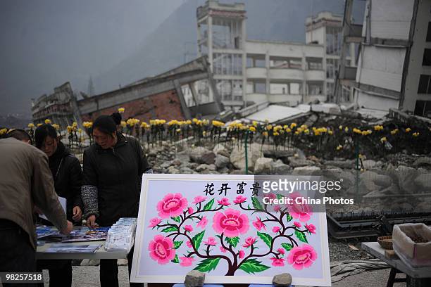 Vendors sell ornaments to people who came to mourn the victims of the Sichuan earthquake on May 12 at the site of Xuankou Middle School on April 5,...