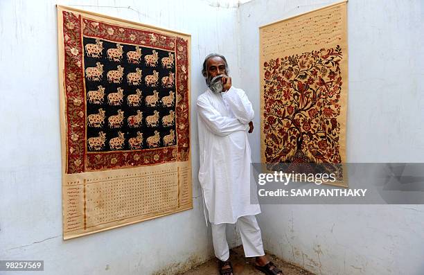 Indian graphic designer Subrata Bhowmick poses with his calendars in Ahmedabad on April 5, 2010. The Brno Biennale Association in the Czech Republic...