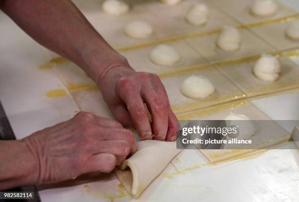 People prepare quark turnovers at the company 'Mecklenburger Backstuben' in Waren, Germany, 31 January 2018. The company does not only have 60 bakery...