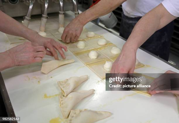 People prepare quark turnovers at the company 'Mecklenburger Backstuben' in Waren, Germany, 31 January 2018. The company does not only have 60 bakery...