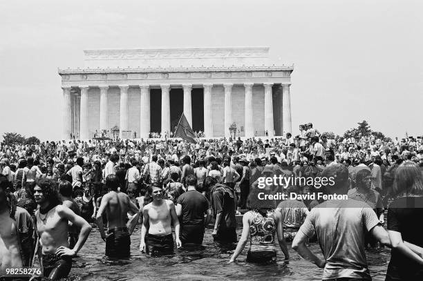 Many shirtless young American antiwar protestors splash around in the Reflecting Pool on The Mall in front of the Lincoln Memorial during a rally...