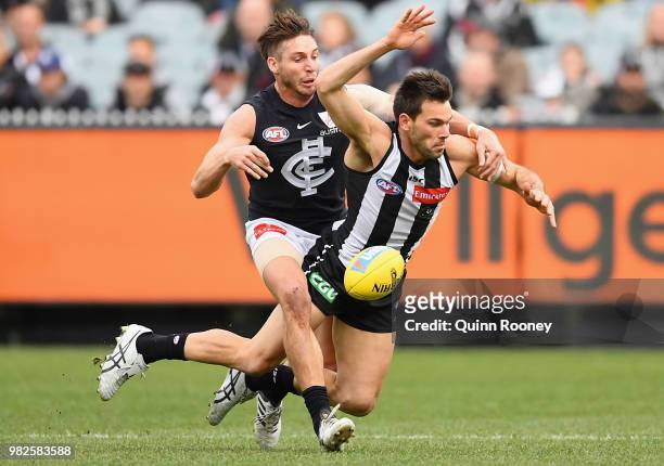 Levi Greenwood of the Magpies is tackled by Dale Thomas of the Blues during the round 14 AFL match between the Collingwood Magpies and the Carlton...
