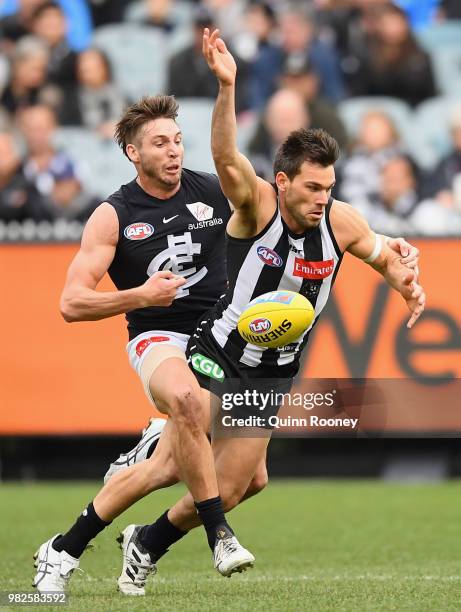 Levi Greenwood of the Magpies is tackled by Dale Thomas of the Blues during the round 14 AFL match between the Collingwood Magpies and the Carlton...