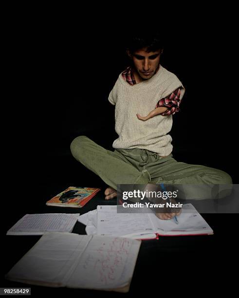 Irshad Ahmad writes with his right foot on his note book on March 29, 2010 Seever, Lolab, 140 km north of Srinagar the summer capital of Indian...