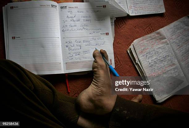 Irshad Ahmad writes with his right foot on his note book on March 29, 2010 Seever, Lolab, 140 km north of Srinagar the summer capital of Indian...