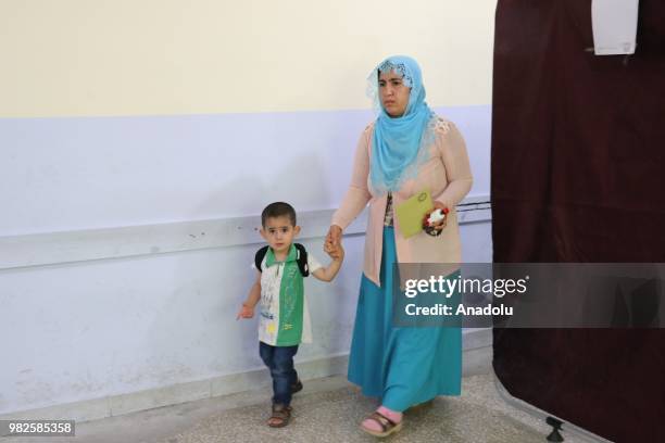 Voter with her child arrives at a polling station to cast her vote during the parliamentary and presidential elections, in Siirt, Turkey on June 24,...