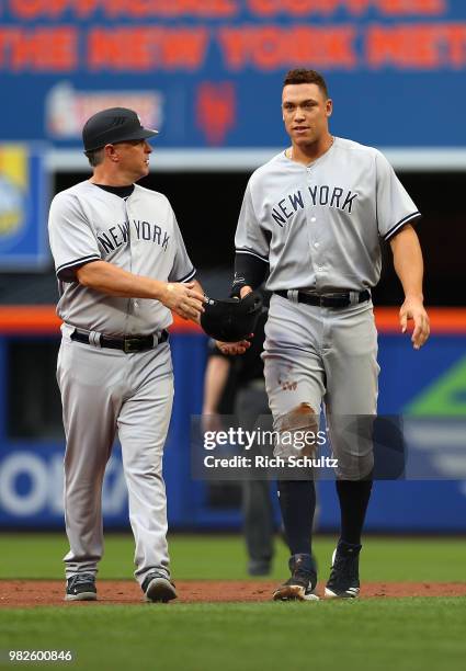 Aaron Judge of the New York Yankees is looked after by third base coach Phil Nevin after a hard slide into second base in the first inning against...