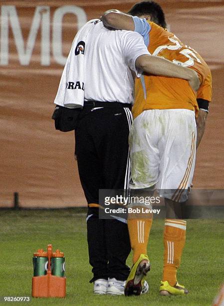 Brian Ching of the Houston Dynamo is helped off the field after injuring his left hamstring against Real Salt Lake at Robertson Stadium on April 1,...