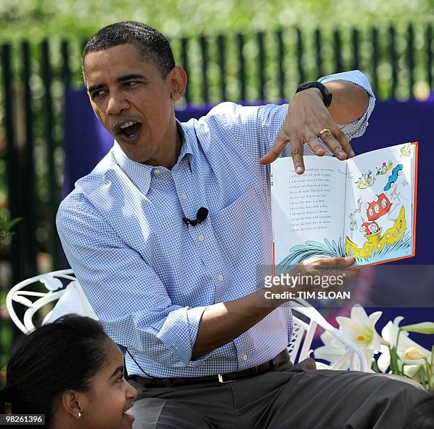 President Barack Obama reads "Green Eggs and Ham" with daughter Malia on the South Lawn of the White House during the Annual Easter Egg Roll on April...