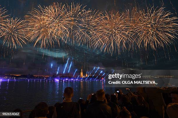 People look at light show and firework on the Neva River in central Saint Petersburg, late on June 23 during the "Scarlet Sails," a romantic holiday...