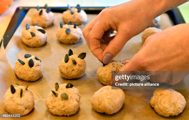 An educator decorates small rolls with pumpkin seeds in Erfurt, Germany, 29 January 2018. A joint cooking class is part of the 'Ich kann kochen!'...