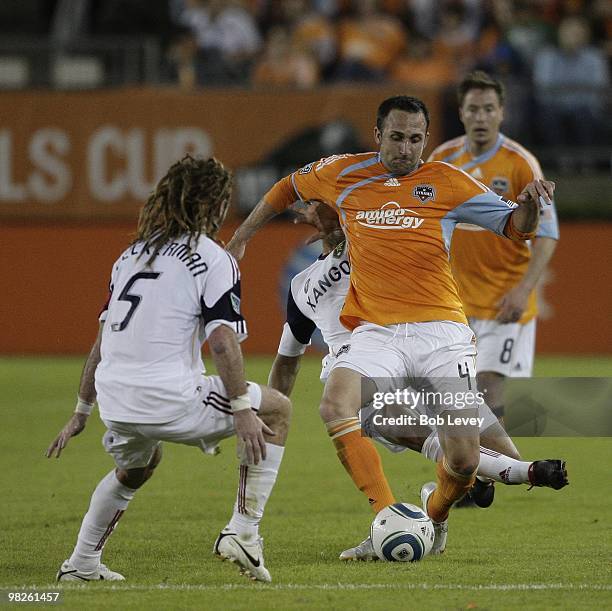 Ryan Cochrane of the Houston Dynamo brings the ball up the field as he is defended by Kyle Beckerman of Real Salt Lake on April 1, 2010 in Houston,...