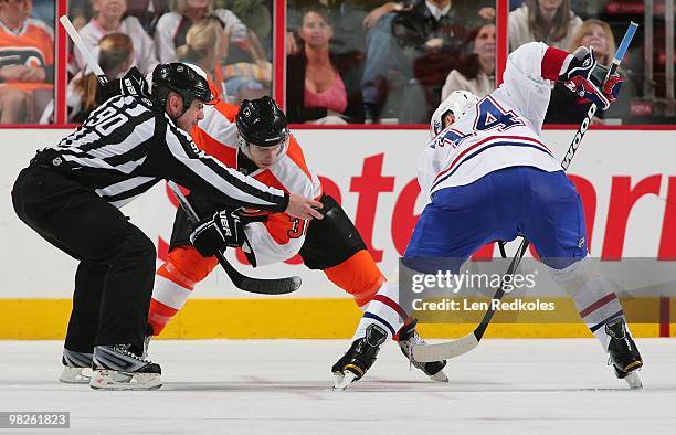 Limesmen Andy McElman readies to drop the puck on a face-off between Darroll Powe of the Philadelphia Flyers and Tomas Plekanec of the Montreal...