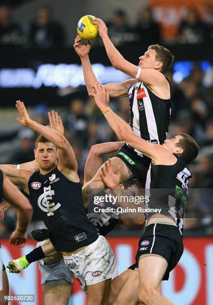 Will Hoskin-Elliott of the Magpies marks over the top of Liam Jones of the Blues during the round 14 AFL match between the Collingwood Magpies and...